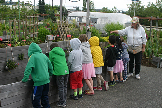 Bonnie Hedman shows young students a raised bed