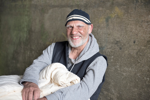 Portrait image of a happy mature man outdoors with a blanket