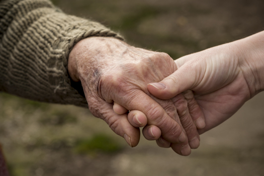 Old and young person holding hands. Elderly care and respect