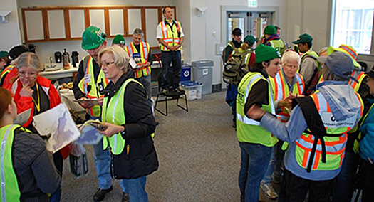 Photo of people wearing safety vests in small group discussions