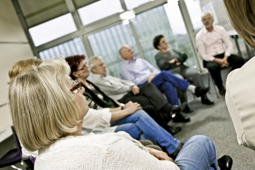 Photo of part of a caregiver discussion circle includes middle-age and older men and women