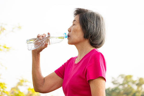 Woman staying hydrated by drinking a bottle of water