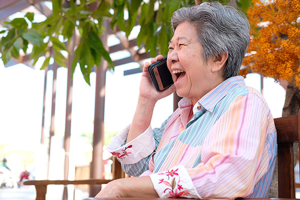 elderly asian-american woman talkin gon the phone