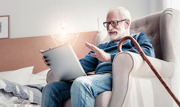 elderly man working on his laptop