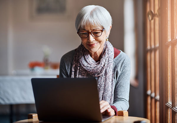 elderly woman working at her laptop