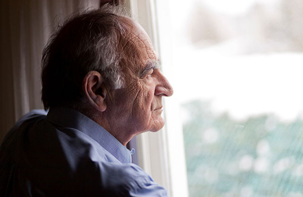 depressed man looking out the window