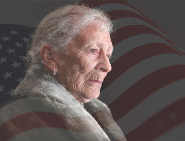 Sad elderly woman with american flag in the background