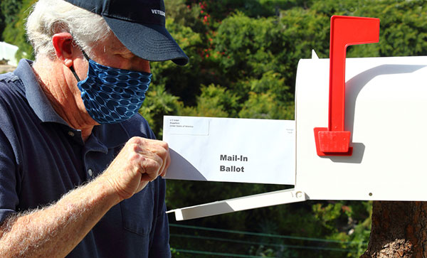 elderly mail placing his ballot into his mailbox