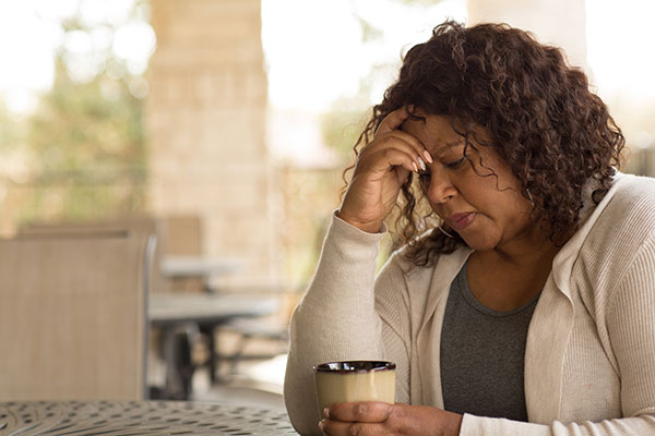 woman worrying while drinking a cup of coffee