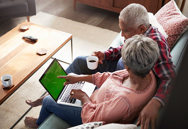 elderly couple doing online research on their laptop