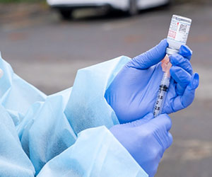 A healthcare worker prepares a dose of the Moderna COVID-19 vaccine at a recent clinic for front-line health care workers.