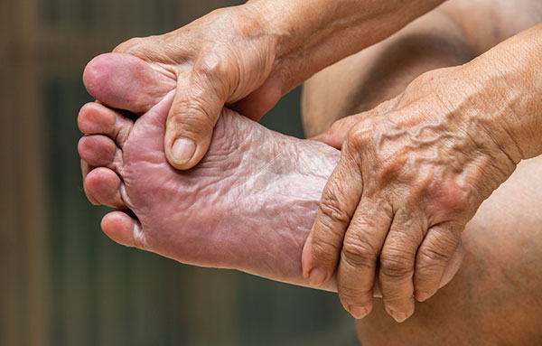 elderly woman giving herself a foot massage