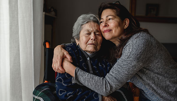 elderly mother and daughter hugging