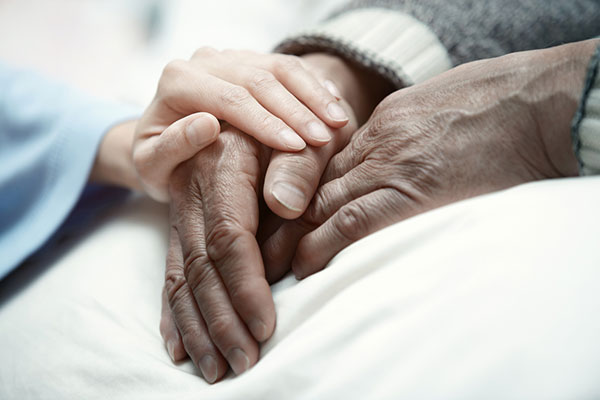 caregiver holding hands of elderly patients