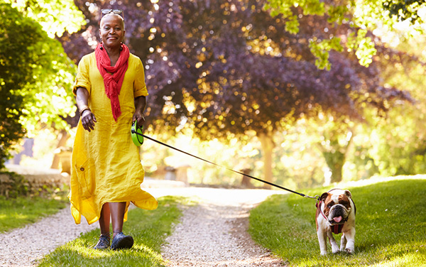 african american woman walking her dog in the park