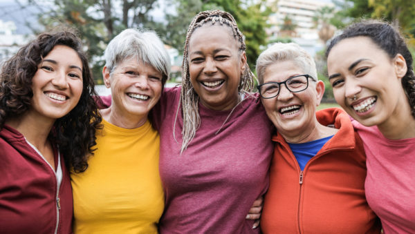 Happy multi generational women having fun together - Multiracial friends smiling on camera after sport workout outdoor - Main focus on african female face