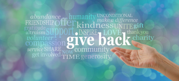 female open hand gesturing towards the words GIVE BACK surrounded by a relevant word cloud against a blue bokeh background