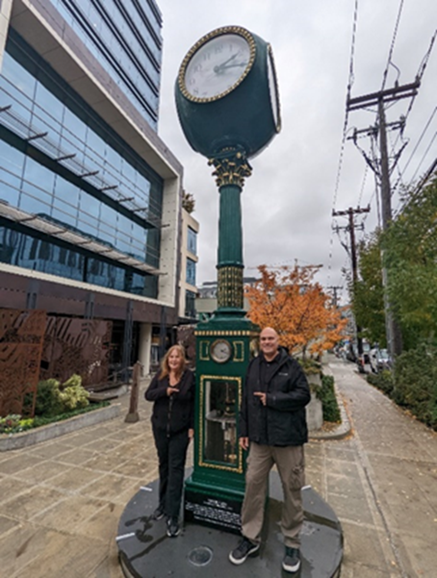 Mark Mendez Mayer & his mother, Heidi Mayer, in front of Joseph Mayer’s Magnificent Clock at Mayer Plaza