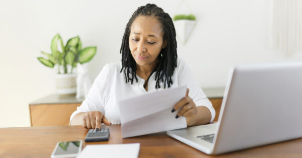 A black woman using computer in modern kitchen interior