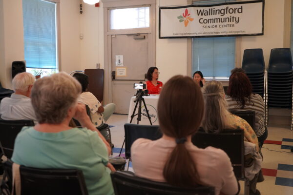 An audience listens to speakers converse at a Civic Coffee event on social connectivity